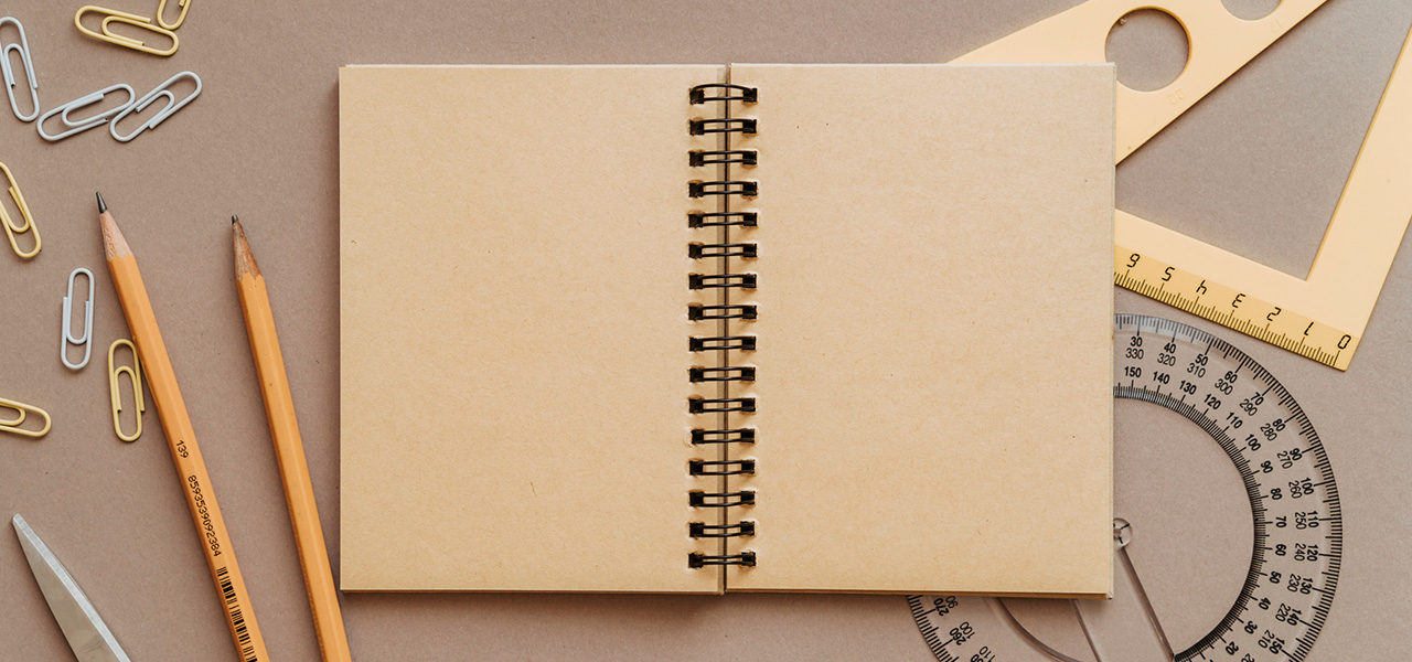 Caderno, lápis e compasso